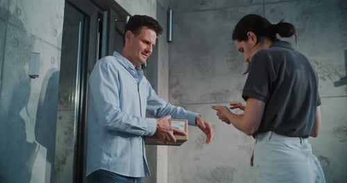 Female Mail Carrier Delivering Small Parcel Box Businessman Signing POD on Smartphone