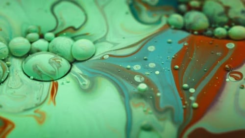 Green acrylic colors and bubbles moving in oil liquid