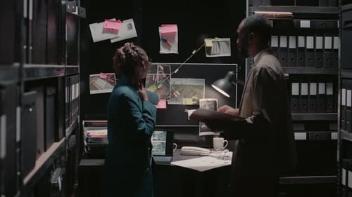 Investigators Analyzing Crime Evidence in Tense Office Setting