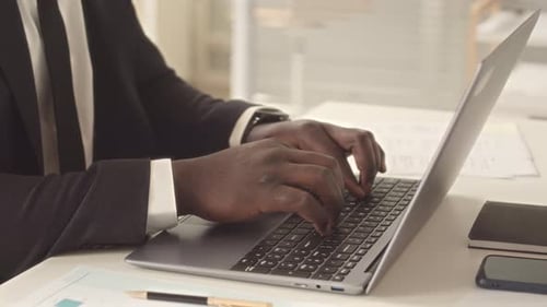 Man Typing on Laptop in Bright Office