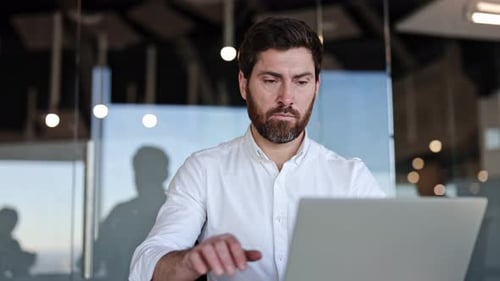 Focused Businessman Working on Laptop in Modern Office Bearded Entrepreneur Writing Notes