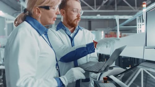 On High Tech Factory Female and Male Engineers Talk and Use Computer for Programing Pick and Place