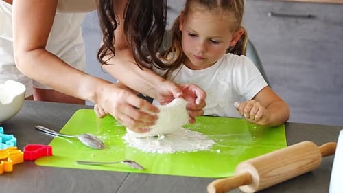 Young Mother and Her Daughter Making Dough for Cookies on Kitchen Happy Family in Home Kitchen