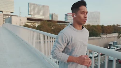Young man in wireless headphones on a morning run