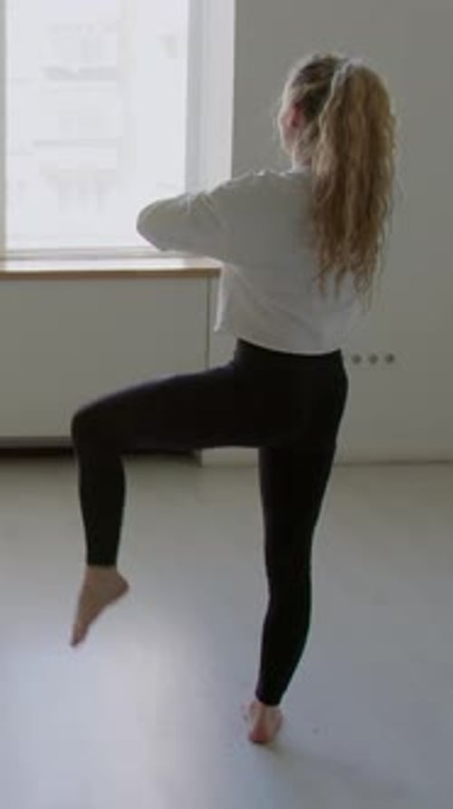 Woman Doing Knee Raises Exercise Indoors