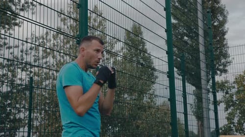 Man Boxing and Punching in Outdoor Urban Setting