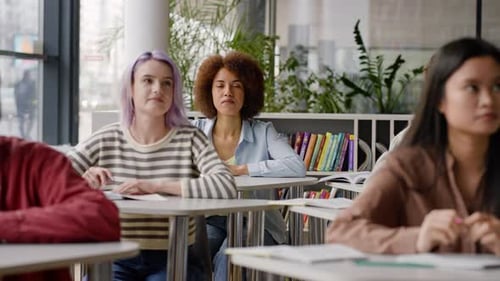 Diverse Students Sitting at Desk Taking Notes From the Lecture for Their Study in College Library