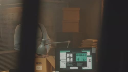 Detective Agent Examining Evidence Box in Office