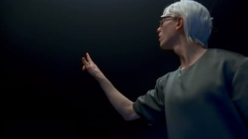 Man With White Hair Gesturing in a Dark Space