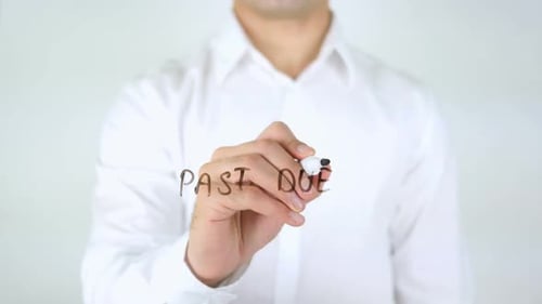 Man Writes Past Due on Clear Surface