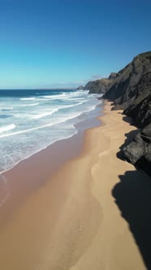 Aerial view of sandy beach and rocky cliffs, Portugal.