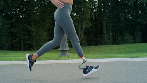 Close Up Handicapped Athlete Running on Asphalt Road. Fit Girl Training Outdoors