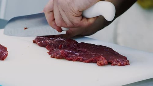 Close-up of Chef Dicing Red Meat on Cutting Board