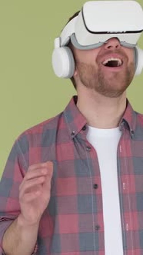 Surprised Man in Virtual Reality Headset on Yellow Background in Studio Vertical Video