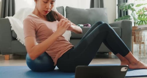 Asia strong woman in sportswear with calm feeling warming up stretching with fitness ball.