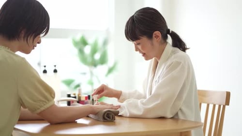 Woman Applying Nail Polish in Bright Salon