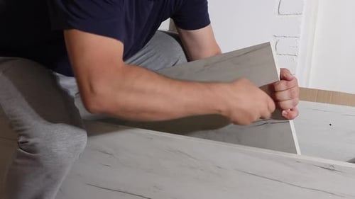Adult Assembling Furniture with Screwdriver Indoors