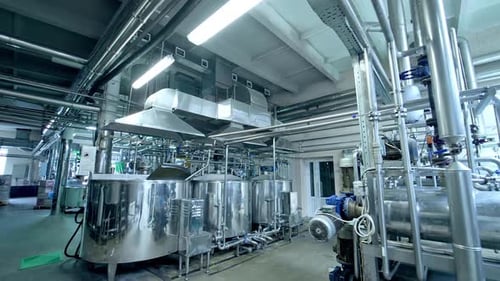 A walk between the shiny silver cisterns at the dairy plant.