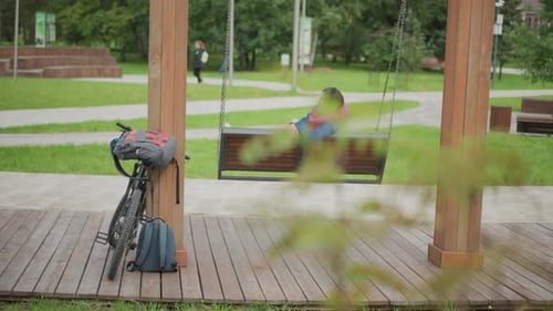 Woman Relaxing on a Swing in a Public Park