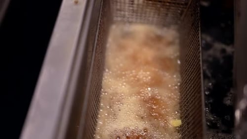 Professional Deep Fryer in Restaurant Kitchen French Fries Frying in Boiling Oil Closeup View