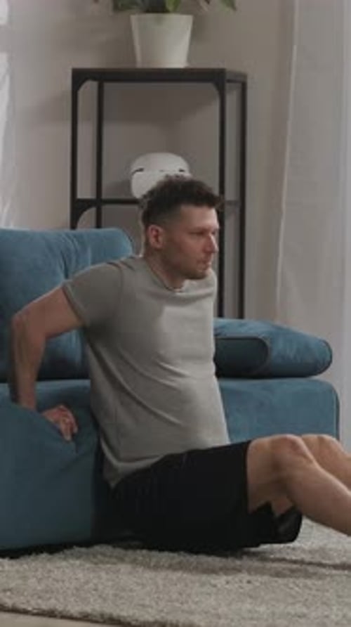 Man Working Out Using Couch for Tricep Dips