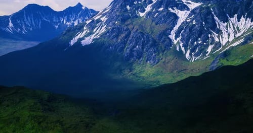 Majestic Mountain Range with Lush Valleys and Snowy Peaks Under Bright Sky