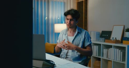 Young Adult on Video Call at Desk Late at Night