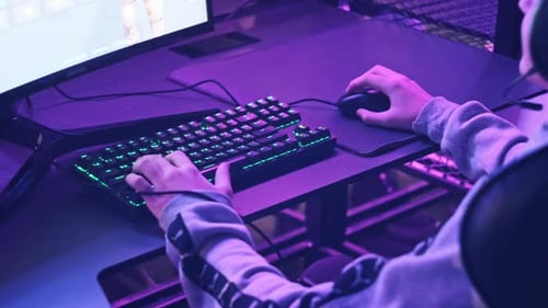 Young Gamer Sits in Gaming Chair and Plays Video Game at ESport Club