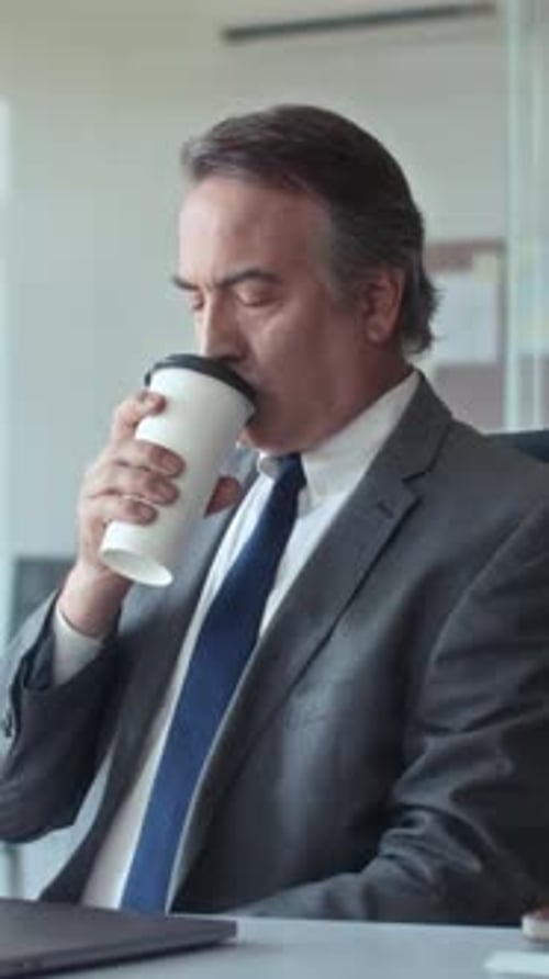 Pensive Aged Entrepreneur Drinking Coffee on Break at Office