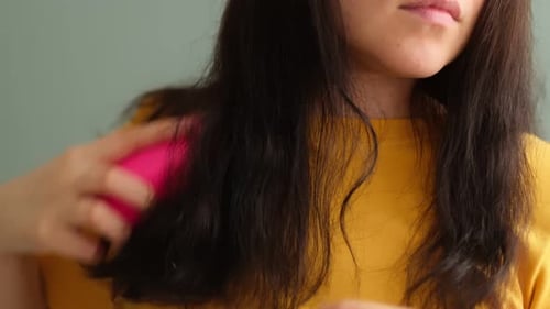 Woman Brushes Dark Hair with Pink Brush