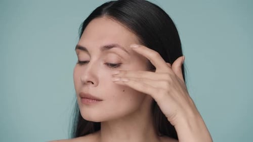 Woman Touches Face in Close-up Studio Shot