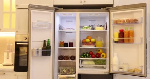 Modern refrigerator with different fresh food products. Camera moving forward