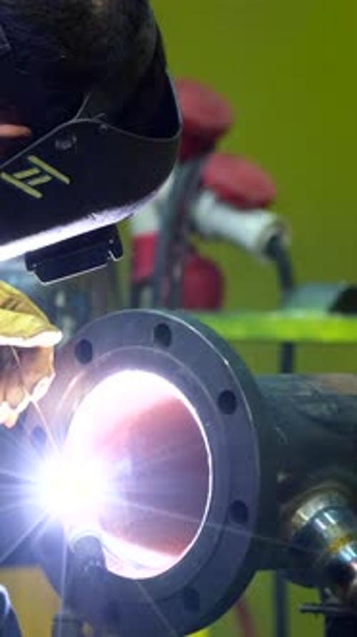 Lumière vive provenant d'un technicien soudant de l'acier ensemble dans l'atelier de l'usine