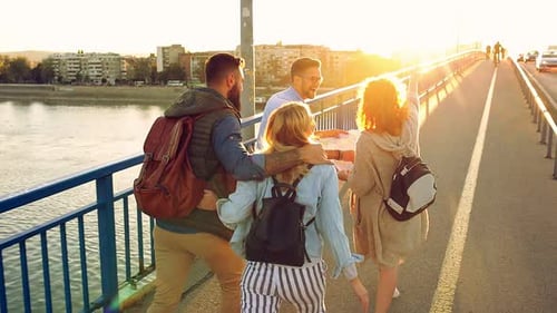 Group of tourists enjoying on vacation, young friends having fun walking on city street.