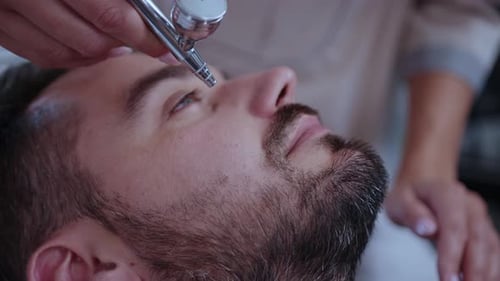 Man Receives Airbrush Makeup Application Close Up