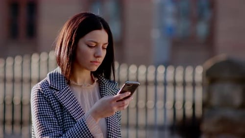 Woman Using Phone in Urban Environment