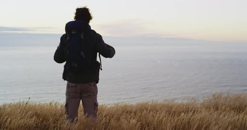 Backpacker Enjoying Ocean View at Sunrise