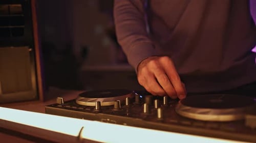 Les mains de DJ ajustent l'équipement pour créer un mix de musique lors d'une soirée en gros plan