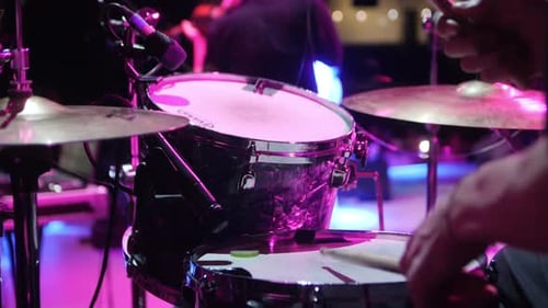 Musician Plays Drum Set with Wooden Sticks at Rock Festival