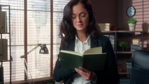 Businesswoman Reading and Writing in Office
