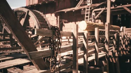 Detailed View of Rustic Lumber Mill Structure with Logs and Wooden Pathways