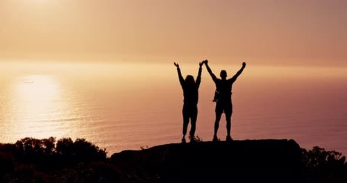 Couple, silhouette and hiking with high five at sunset with ocean, success