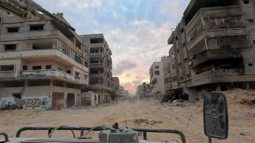 La patrouille avancée israélienne Humvee avance dans une zone bâtie après des attaques à la roquette