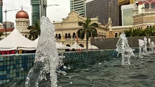 A
água cai de perto ou da fonte para uma pequena piscina na cidade. Câmera lenta