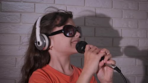 Energetic Child Sings Into Microphone With Headphones
