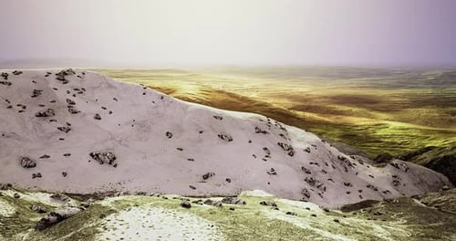 Snowy Mountains with Rocky Terrain Under a Soft Light in an Open Valley
