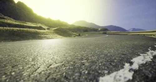 Serene Mountain Road Winding Through Green Hills Under a Bright Sun