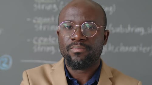 Professeur de sexe masculin regardant la caméra