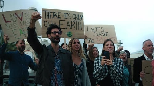 Un groupe d'activistes divers participe à une manifestation contre les usines de pollution en criant un slogan avec colère