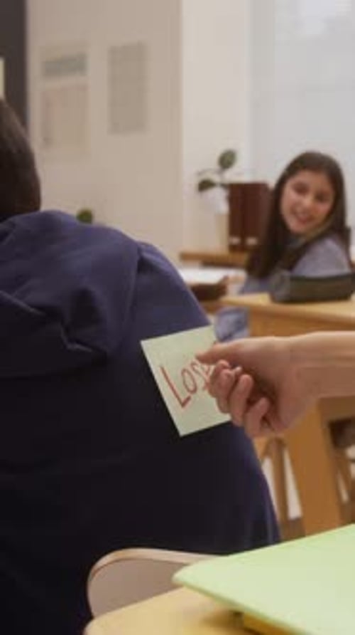 Kid Sticking Loser Note on Back Vertical